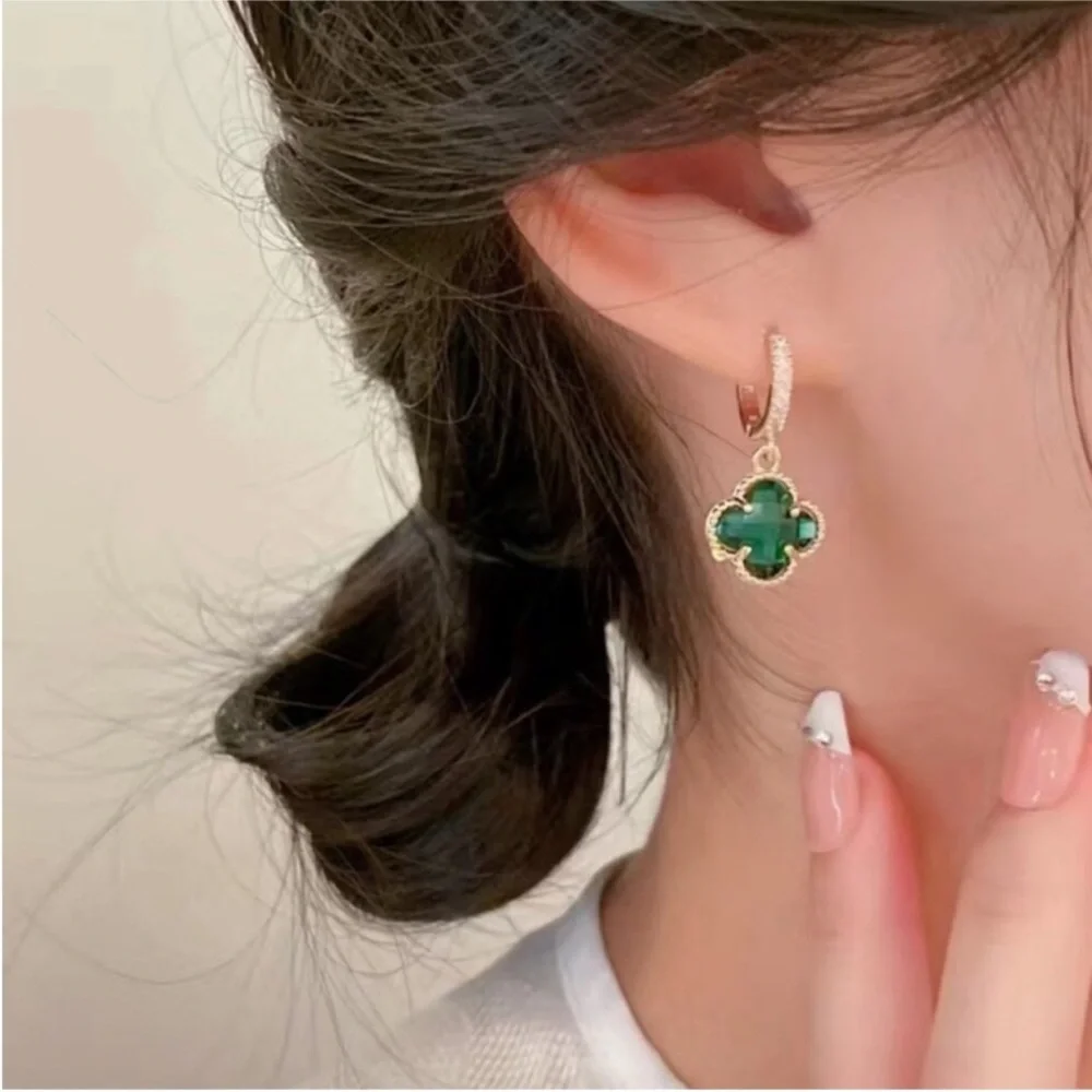 clover-shaped dangle earrings featuring green stones and gold plating with paved
